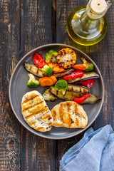 Grilled chicken with grilled vegetables on a wooden background. Healthy eating.