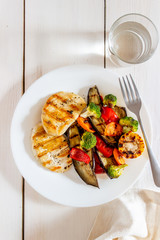 Grilled chicken with grilled vegetables on a wooden background. Healthy eating.