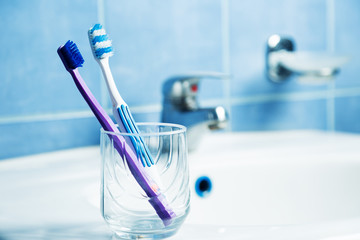 Toothbrushes in a glass at bathroom