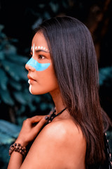 The beautiful woman paint blue color cross her nose,circle of white color above eyes,looking...