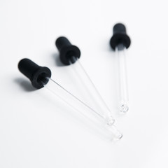  Three pipettes for cosmetics. Black eyedropper on a white background.
