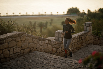 Fototapeta premium Young happy sportswoman jogging in nature.