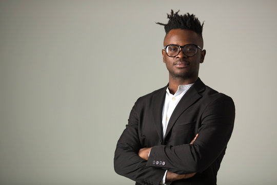 handsome young african man in black suit wearing glasses