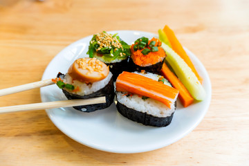 Rice Sushi is a lump of meat on white plate put on wood table  and eaten with sauce in Japanese food restaurant is a popular dish in Thailand