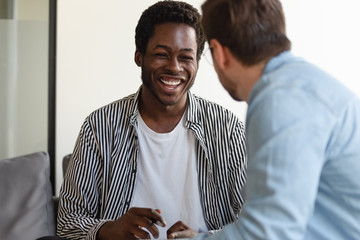 Diverse colleagues having fun, African American man laughing at joke