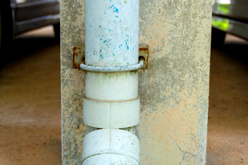 PVC pipe is a sewerage that walks outside the building next to the pole