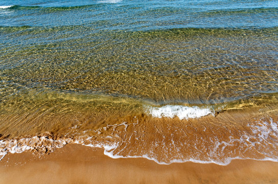 Gournes, Heraklion, Crete, Greece. October 2019. Colourful sea with waves breaking on the Ambrosia Beach at Gournes.