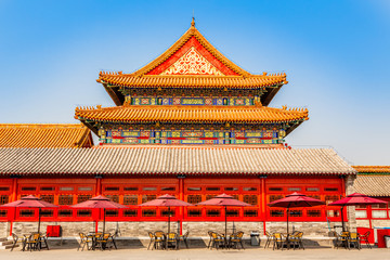 Fototapeta premium Summer cafe with tables and umbrellas at the wall of one of the royal emperor palace in Forbidden city, Beijing, China