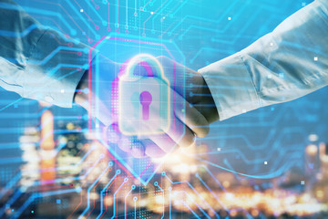 Double exposure of lock icon hologram on city view background with two people handshake. Concept of safe business
