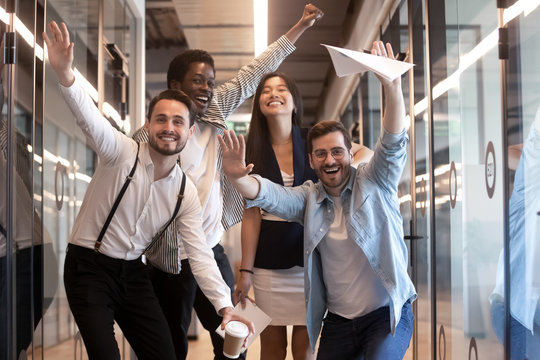 Portrait happy diverse employees celebrating business victory in hallway