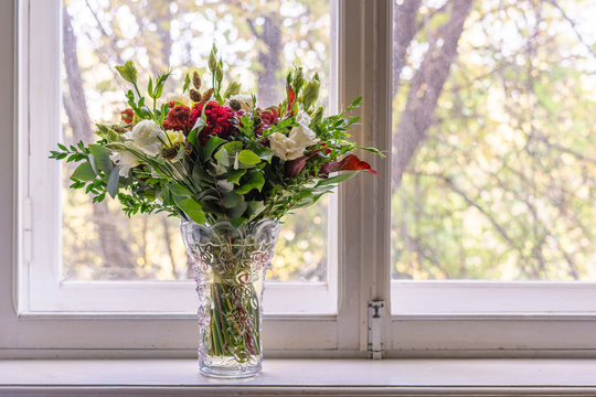 a gorgeous bouquet of the various flowers standing next to the window decorating the home interior design