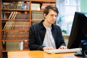 young male student manager in the college doing study work with books