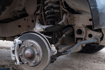 Naklejka premium Car wheel repair. The wheel is removed. The machine stands with a jack. You can see the brake drums, damping springs, struts, suspension, wheel arch.