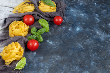 Ingredients for cooking Italian pasta. Pasta, basil, cheese, cherry tomatoes, olive oil, egg, yolk. On a light background. Copy space. 
