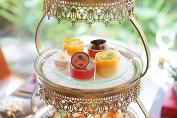 Afternoon tea. A selection of assorted dessert on the second tier including mini mango tart,...