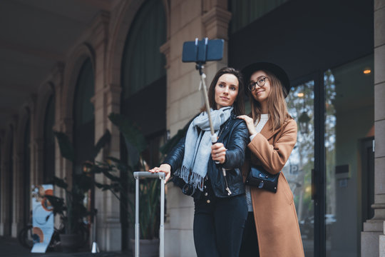 Girlfriends tourist taking photo selfie together on smartphone mobile. Blogger hipster travels in europe hotel. Vacation holiday friendship concept. Travelers self cellphone internet technology