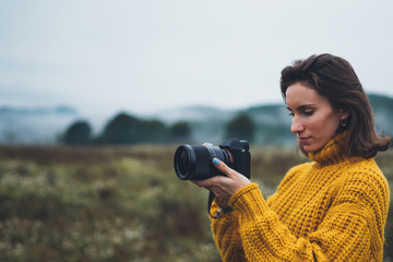 photographer traveler take photo on video camera closeup on background autumn foggy mountain,...