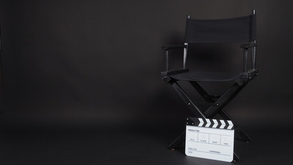Clapperboard or clap board or movie slate with director chair use in video production ,film, cinema industry on black background.