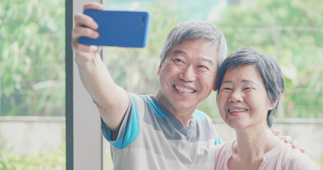 Naklejka premium elder couple take selfie
