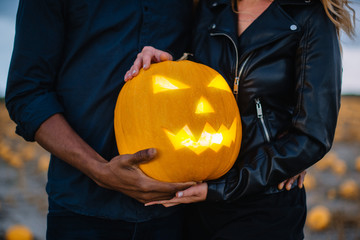 Couple holding scary face pumpkin, close-up, concept halloween
