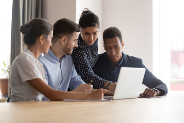 Multiracial successful team working together on project in office
