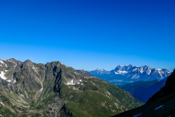 Massive mountain range of Schladming Alps, Austria. The slopes of Alps are steep, partially overgrown with green bushes. Dangerous mountain climbing.Clear and beautiful day. Endless mountain ranges,