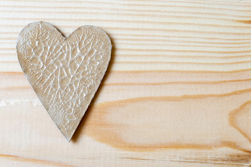 Cardboard heart with cracks lying on a wooden background