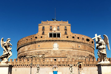 Facade of the Sant'Angelo Castle in Rome with statues of angels, and the blue sky in the background.
