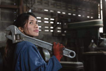 Multiracial diverse Hispanic Asian female engineering worker with industrial wrench training in...