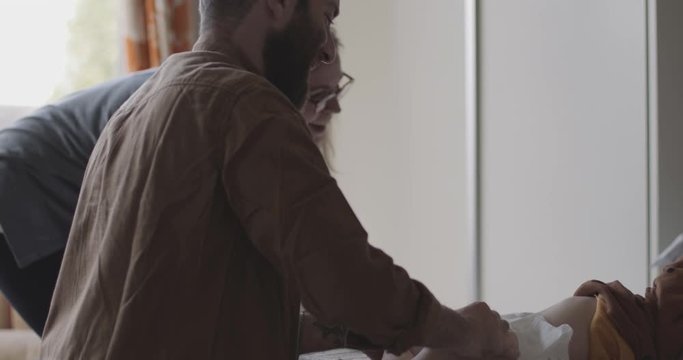 Father changing diapers of baby in bedroom