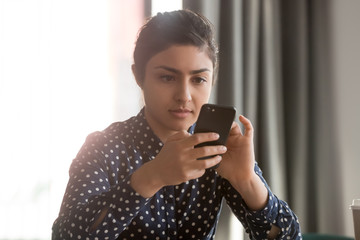 Young indian woman using virtual assistant or texting messages