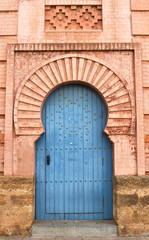 Fototapeta na wymiar Beautiful Light Blue Door in a Warm Golden Red Brick Archway from Cadiz, Spain