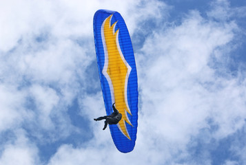 Paraglider flying wing in a blue sky