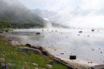 fog fading reveals stones and shore in fjord near Grunnfor, Norway