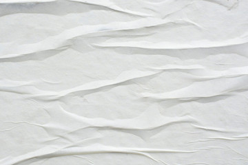 Fototapeta na wymiar White sheet of crumpled paper glued to the wall.