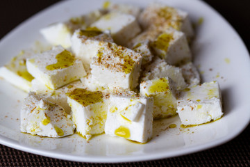 Slices of feta cheese with olive oil and spices