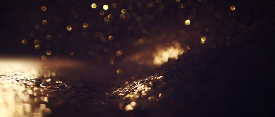 background of abstract glitter lights. gold and black. de focused. banner