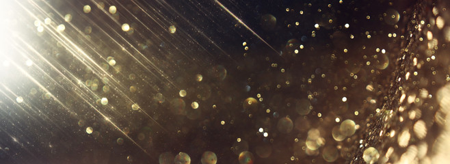background of abstract glitter lights. gold and black. de focused. banner