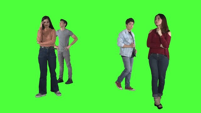 Group of confused young people thinking something while walking back and forth in the studio. Shot in 4k resolution with green screen background