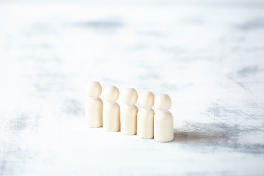 Wooden men stand in a row.