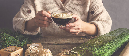 Christmas and zero waste, eco friendly packaging. Woman is wrapping gifts in craft paper on a...