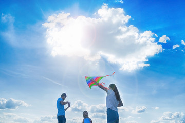 Family is flying a kite in a field