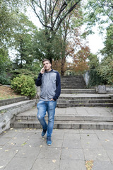 Fototapeta premium Young man using his mobile in the street