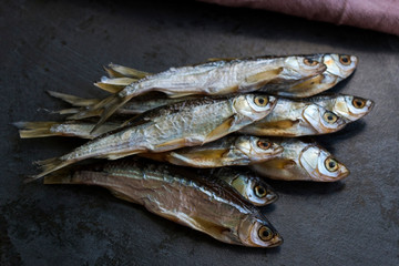 Salted dried river fish for beer on dark background