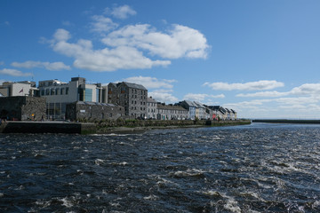 Obraz premium Famous view of the brightly painted houses of Galway city and the River Corrib rushing past on a sunny summer day