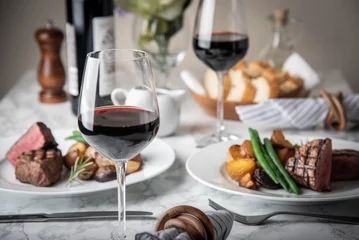 Rolgordijnen wijnglazen op eettafel met steak © ahirao