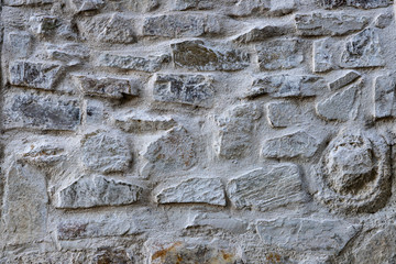 Old beige stone wall background texture close up