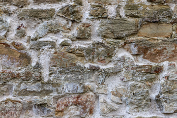 Old beige stone wall background texture close up