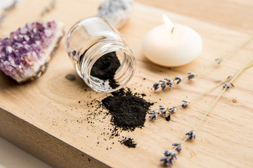 Raw activated charcoal powder in beauty products concept. Lot of copy space. Spa candle burning.