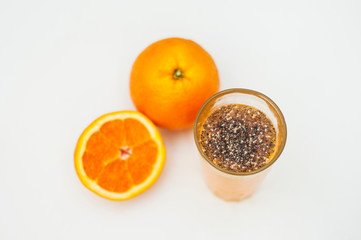 Glass of fresh orange juice with chia seeds and two oranges on white background. Healthy food.